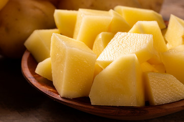 Potatoes and potato sliced on wooden table. Selective focus