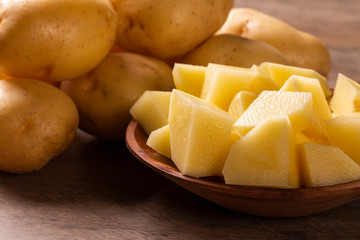 Potatoes and potato sliced on wooden table. Selective focus