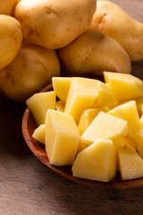 Potatoes and potato sliced on wooden table. Selective focus