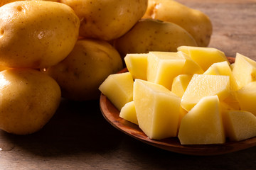 Potatoes and potato sliced on wooden table. Selective focus