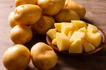 Potatoes and potato sliced on wooden table. Selective focus
