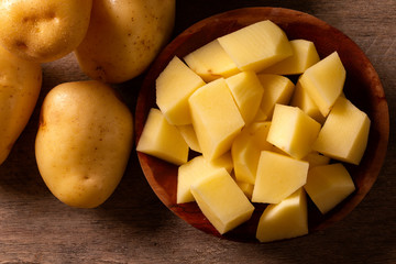 Potatoes and potato sliced on wooden table. Selective focus