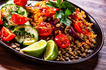 Groats with lentils and vegetables on wooden table