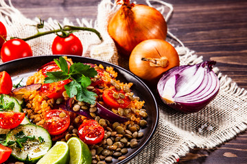 Groats with lentils and vegetables on wooden table