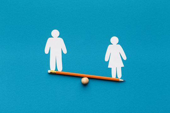 Female figure outweigh male on seesaw, blue background