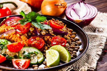 Groats with lentils and vegetables on wooden table