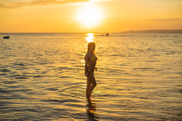 Hot girl in sexy bikini on sunset. Hot young beautiful girl posing in bikini on beach in sunset