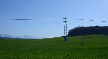 The GR route "Vuelta a la LLanada Alavesa" as it passes through the town of Ullibarri de los Olleros, Basque Country, Spain. fields planted in blue sky and light pole