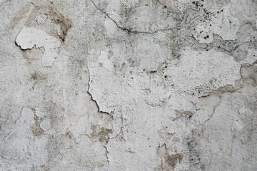 Macro texture of peeled paint on a white concrete wall.