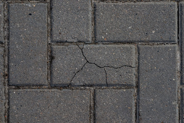 Macro texture of cracked paving slabs. One bad among normal