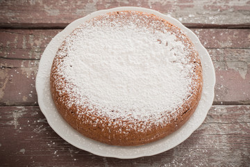chocolate sponge cake on old wooden background.