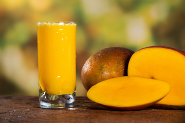 Fresh mango juice and mango fruit with a natural backdrop.