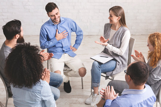 Happy people clapping at support group meeting