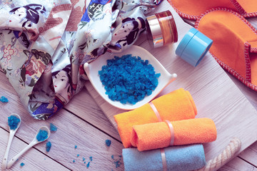SPA consist from silk bathrobe, towels and blue sea salt on a wooden tray