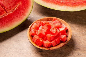 fresh watermelon cut into cubes on wooden bowl