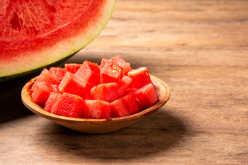 fresh watermelon cut into cubes on wooden bowl