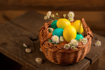 easter eggs in basket on wooden background