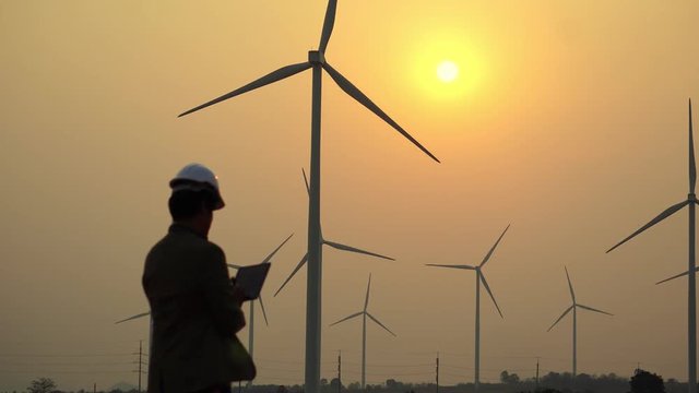 Asian engineers are checking the wind turbine system with a tablet footage 4K