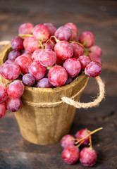 Rose grapes in wooden bucket on a woden table
