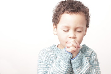 boy praying to God with hands held together