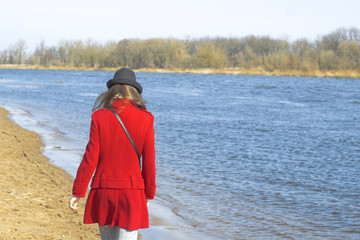 The girl walks along the river bank