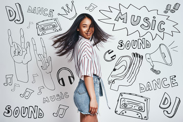 Just dance! Attractive young asian woman in casual wear looking at you and smiling while standing...
