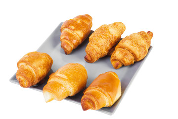Group of six croissants on gray square shaped plate