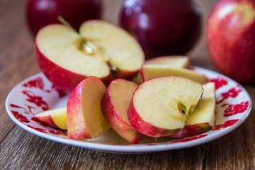 Fresh organic big red apples whole and sliced on wooden table