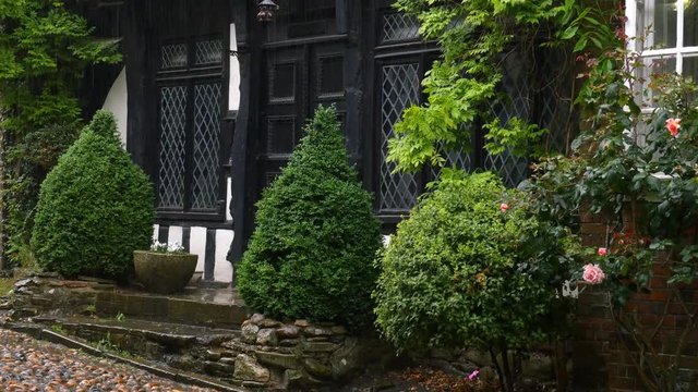 English, historic, tudor style house with diamond pattern leaded glass windows in rainy weather. Rye, West Susex, England.