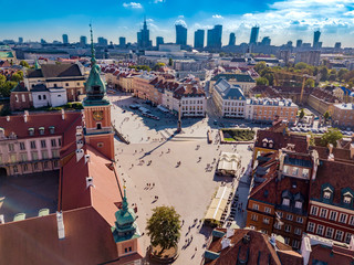 Royal Castle at central square of polish capital - Warsaw. many tourists visit this town in sunny day. There are many historic, old buildings surrounding square and castle. Aerial