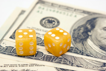 Amber dices and dollar banknotes on white background