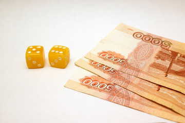 Amber dices and ruble banknotes on white ground