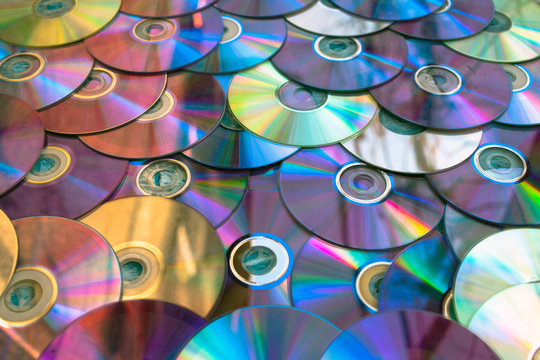 Background on the wall with old damaged discs cd.