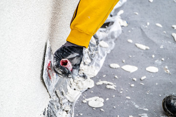 Construction worker plastering and smoothing concrete wall with cement