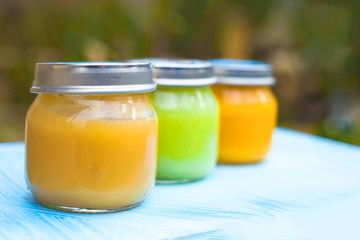 Three glass jars close up with baby puree for the first feeding up