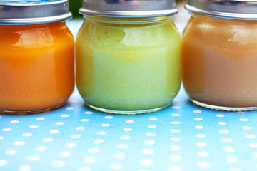 Three glass jars close up with baby puree for the first feeding up