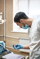 The experience you can count on. Dentist hold tools in his hand prepare to work in the cabinet.