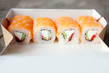 delivery service Japanese food rolls in cardboard box on a wooden background