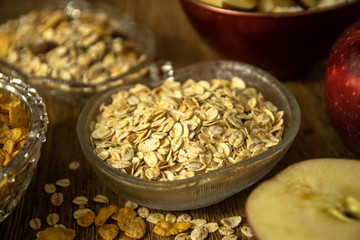 Close up photo of a cereal grain product. Barley flake from whole grain for barley porridge, fresh organic red apple, muesli and corn flakes.