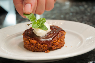 Chef carefully placing mint on dessert