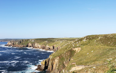 Fototapeta na wymiar Ocean view to the horizon at a green cliff in England's Land's End. Cornwall, UK
