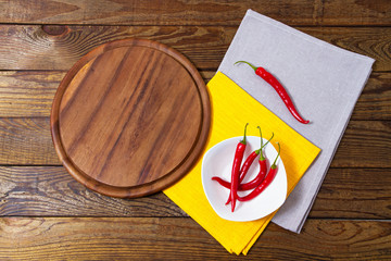 top view - empty pizza desk board on wood table with chili pepper , mock up isolated on white
