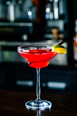 Cosmopolitan cocktail with lime on bar counter in a nightclub