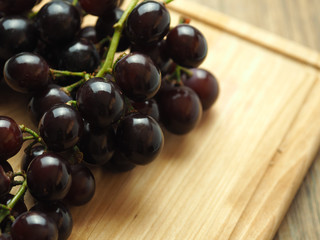 Black grapes on a wooden table