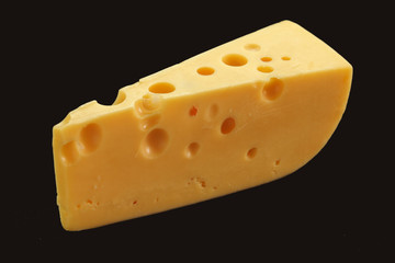 Cheese with big holes against dark background