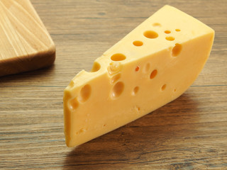 Cheese with big holes on a wooden table