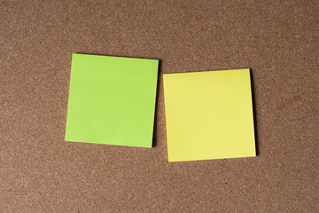 Blank colorful paper sticky note on cork board.green and yellow paper.