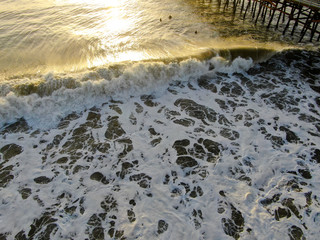 Aerial view of surfers waiting, paddling and enjoying the big waves before sunset time in Laguna...
