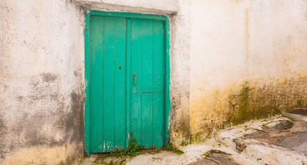 Greece, Kea island. Traditional wooden door on whitewashed stone wall in capital city of Ioulis