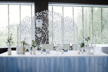 Served for wedding banquet table in blue white. Wedding decoration. Blue napkin with flower on a white plate. Openwork arch.